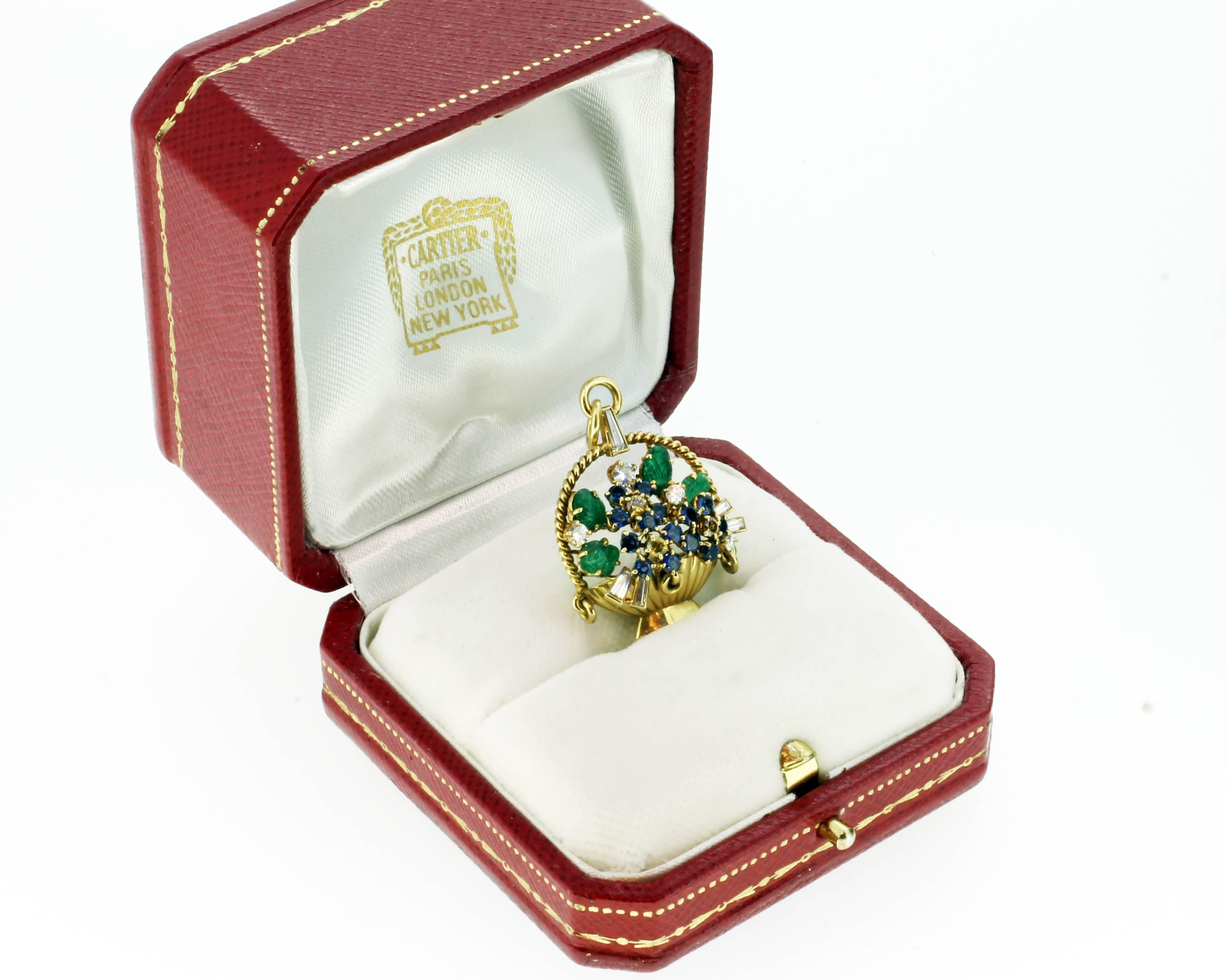 1976 Cariter 'Tutti Frutti' basket moutned in 18ct yellow gold. London. 1976
The central carved emeralds, sapphires, diamonds and yellow sapphires realistically modelled as flowers within a basket brooch. Signed Cartier London and marked with the