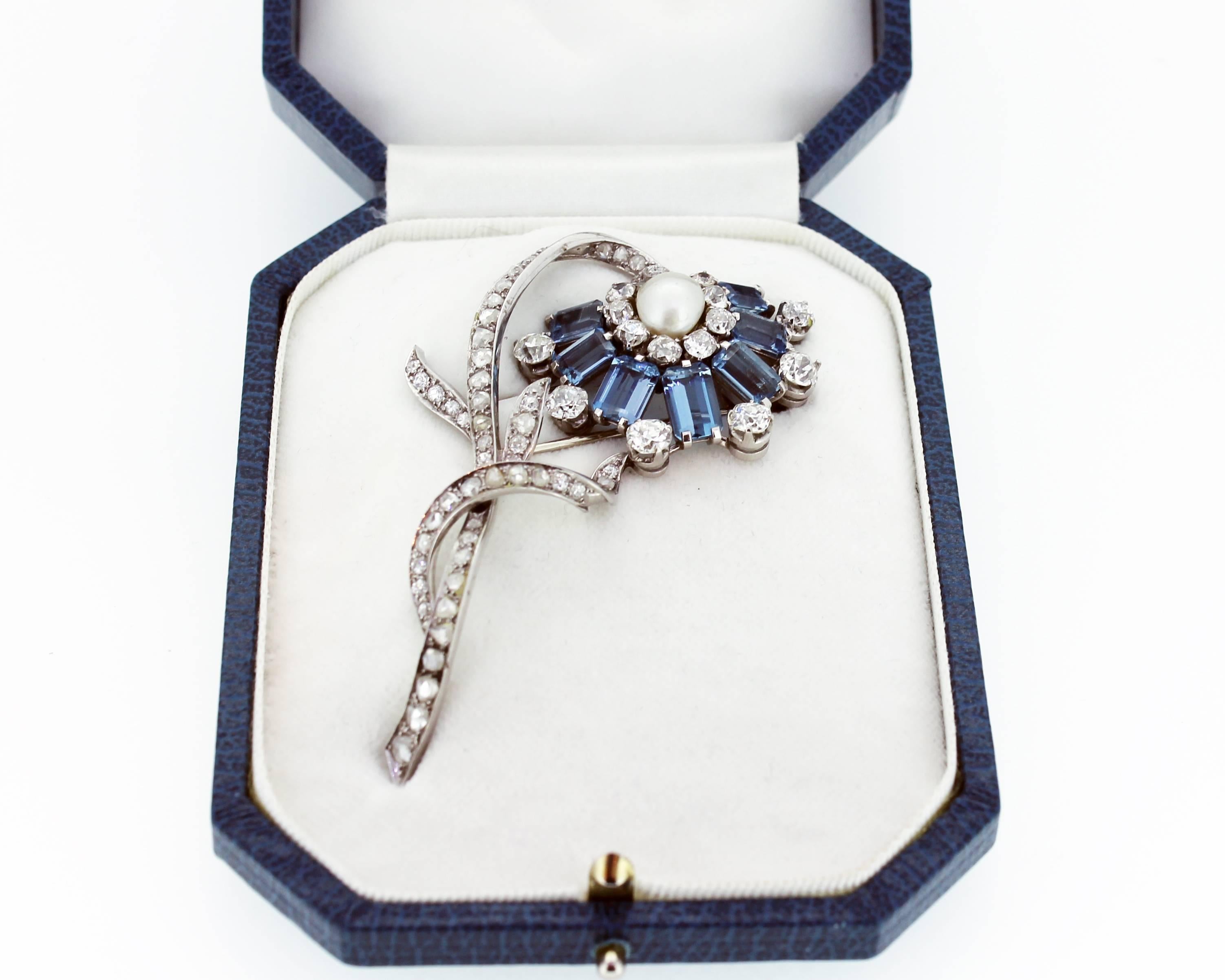 Art Deco aquamarine, pearl and diamond flower brooch mounted in platinum. English. Circa 1930. The central saltwater pearl surrounded by aquamarine and diamond petals and a rose cut diamond set stem. The whole brooch realistically modelled as a