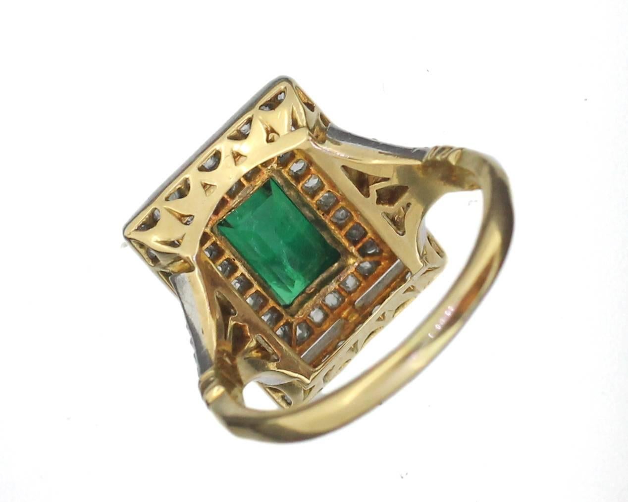 Edwardian Colombian emerald and diamond ring, in 18ct gold. English. Circa 1950's. The rectangular step cut emerald within a double surround of old cut diamonds, and diamond set split shoulders, white metal setting, on an 18ct yellow gold shank.