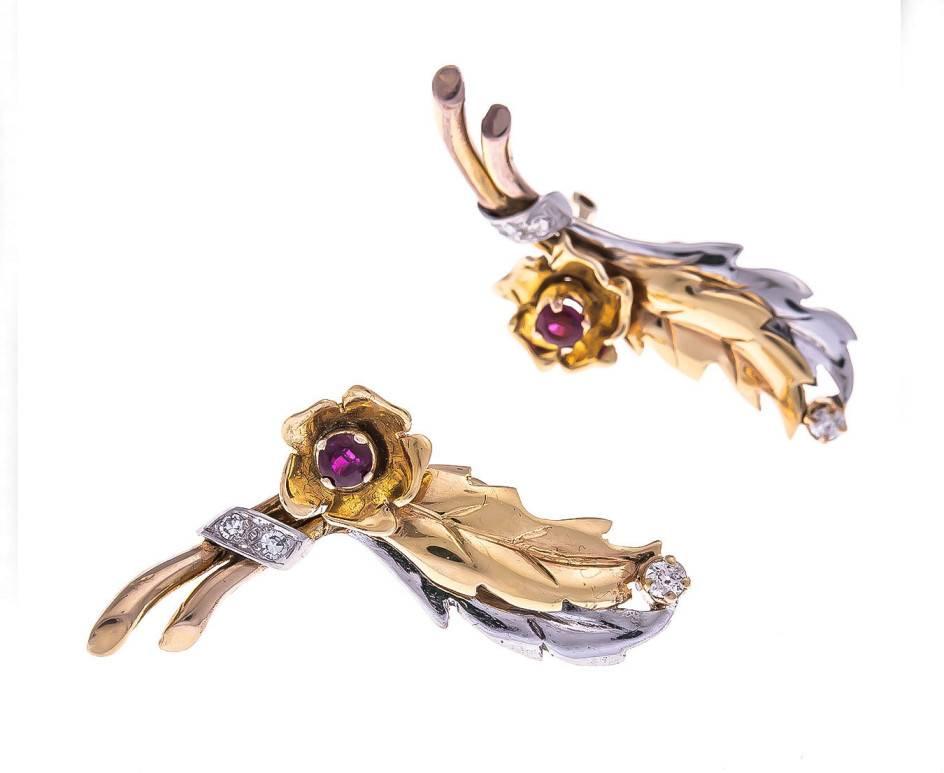 These delightful clip on earrings exhibit a fabulous floral swathe fashioned in yellow and white gold, accentuated with diamonds and set with a rich red ruby at the centre of the flower. A glamorous gift for a ruby occasion or for someone that