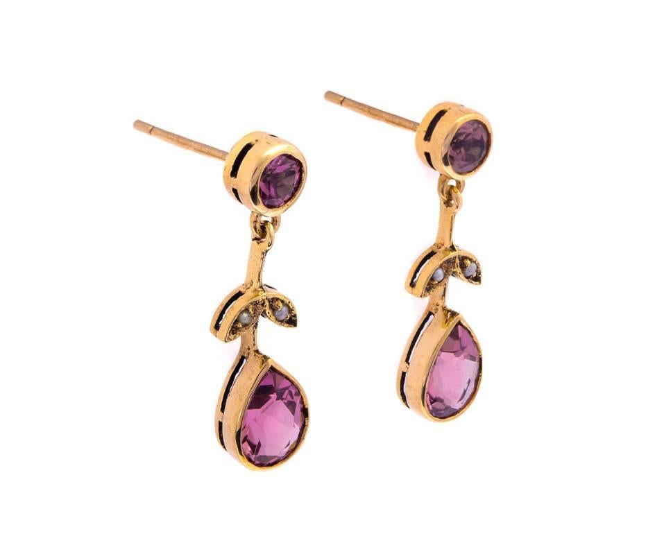 Stunning 1961 Edwardian style drop earrings set with 1.50ct of delightful pink tourmaline. Tiny gleaming seed pearls decorate delicate leaves. A fabulous pair of vintage earrings that add class and style to any ensemble.