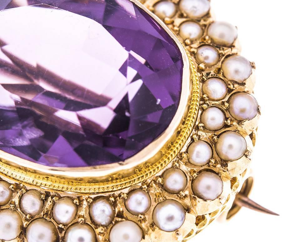 Crafted during the reign of Queen Victoria, this enchanting brooch is set with a deep purple amethyst surrounded by two rows of gleaming seed pearls. Beautifully crafted, the pin and safety catch are still in fully functioning order. Small enough to