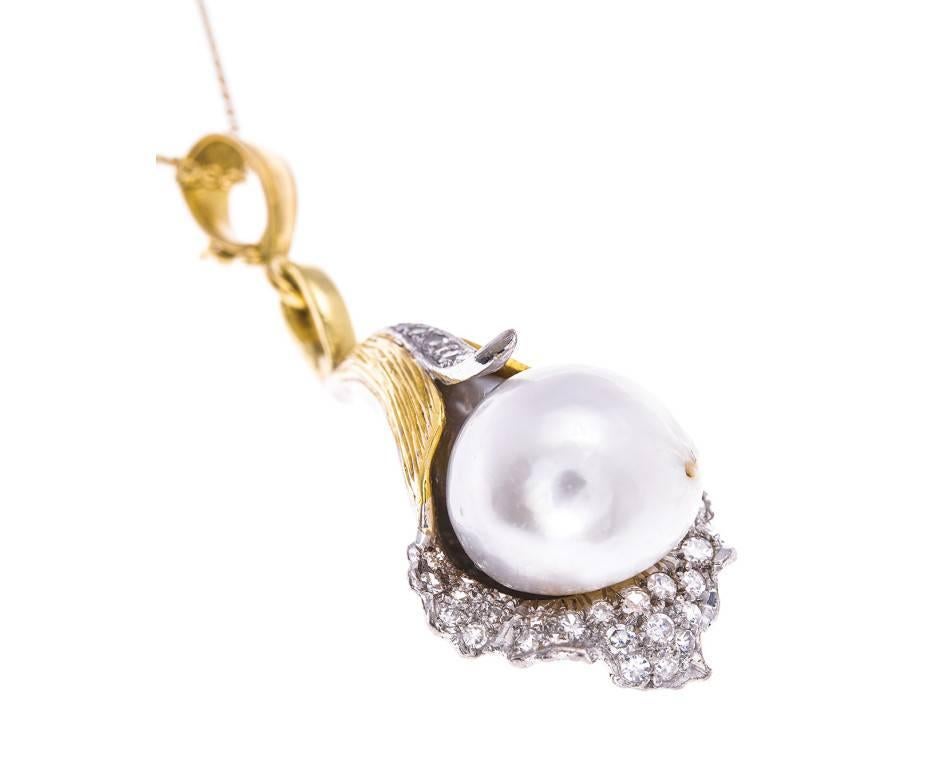 This sumptuous and spellbinding lily pendant exhibits a voluptuous cultured pearl set amidst white gold diamond encrusted petals and accentuated with leaves of yellow gold. This creation is one of organic shimmering beauty and will make a unique and