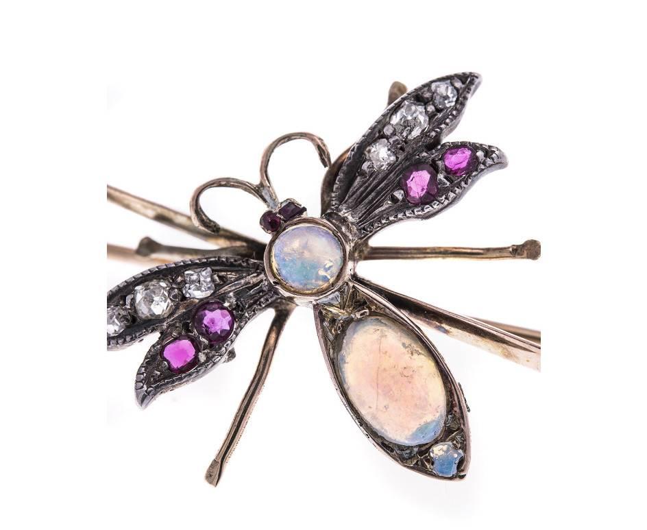 A wonderful late 19th century bee brooch. Each wing is set with diamonds and rubies and the body is set with an oval and round opal cabochon all crafted in yellow gold. A charming gift for any occasion.
