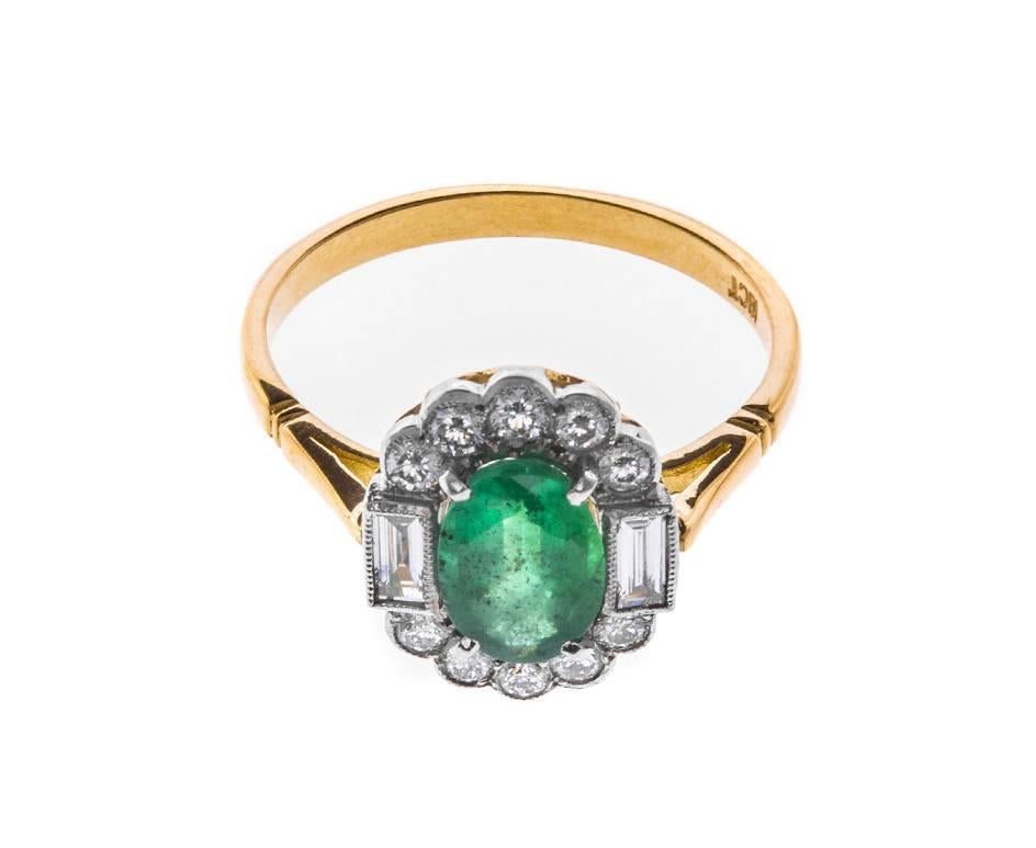 A gorgeous dress ring with a hint of Deco style. Crafted in yellow gold with white gold settings creating the perfect place to showcase a delicious bright green oval faceted emerald and a frame of sparkling round brilliant and baguette cut diamonds
