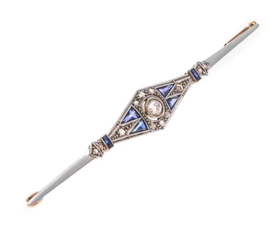 This fabulously elegant Art Deco brooch is fashioned in platinum and yellow gold. Set with old cut diamonds and created blue sapphires in a geometrical design. A beautiful piece for "something old" and "something blue" and for