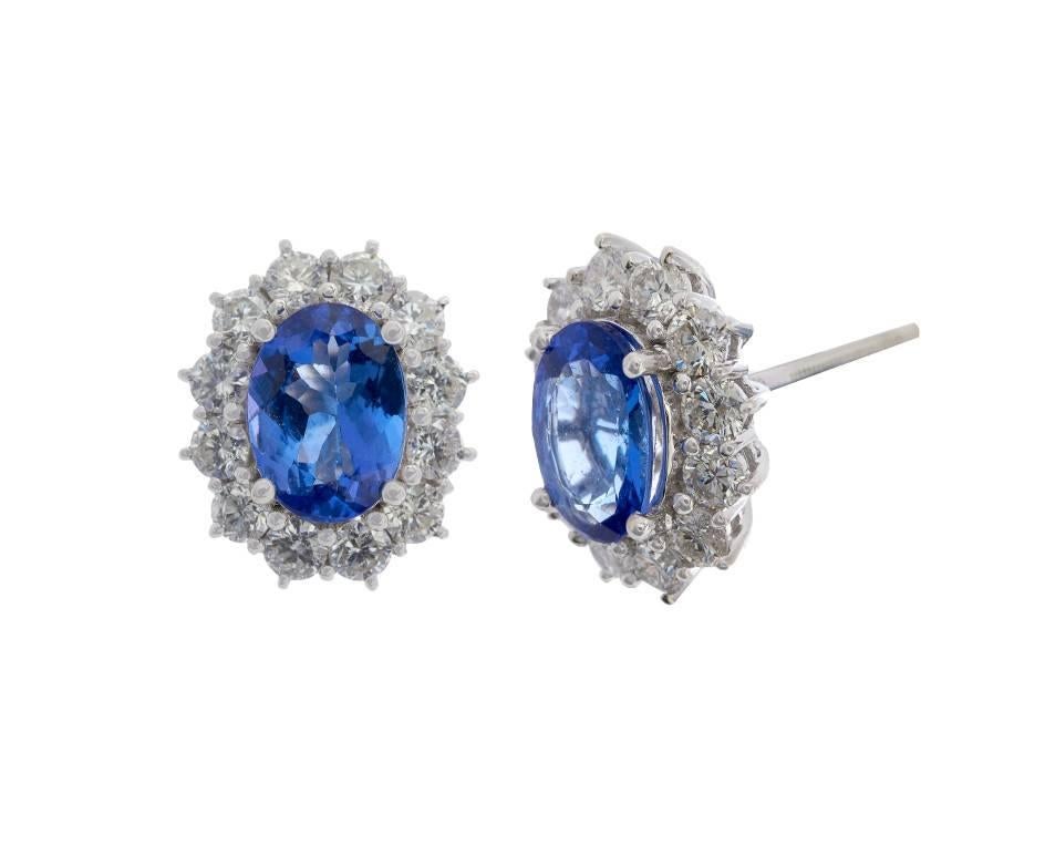 The rich purples and blues of these luxurious tanzanites are accentuated by the frame of approximately 1.20ct of bright diamonds around them. Crafted in white gold these pretty vintage style cluster earrings would make a lovely surprise for a lucky