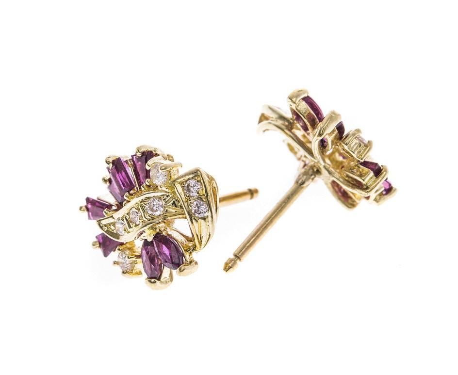 Fabulous vintage cluster earrings crafted in bright yellow gold and set with an array of fancy cut rubies and round brilliant cut diamonds. An opulent and unique gift for a ruby occasion such as a July birthday or anniversary.