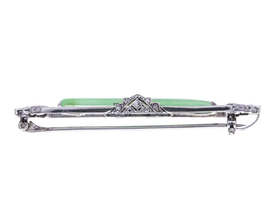 A beautiful specimen of the Roaring 20's. An Art Deco brooch crafted in platinum and 18ct white gold, set with a gorgeous jadeite and twinkling baguette and round diamonds. The perfect accessory to a light weight jacket or little black dress.