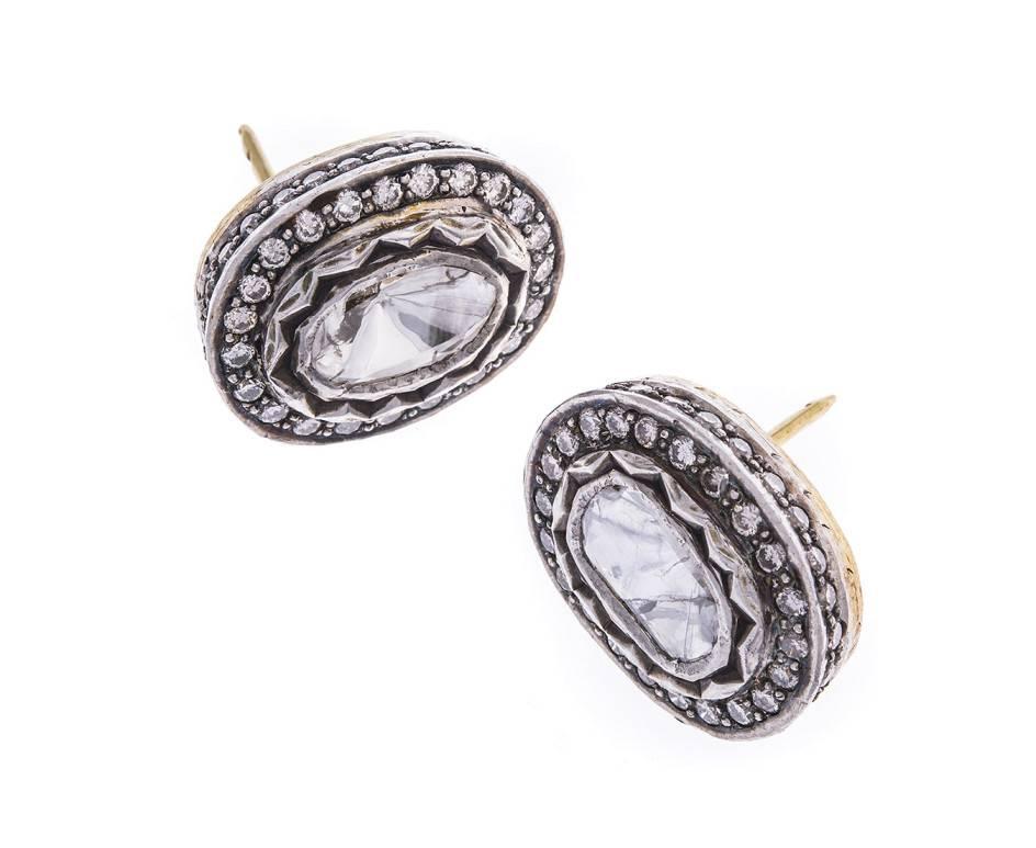 A large pair of statement earrings set with oval diamonds in a foil back setting and round brilliant cuts to the halo and set gallery. Set in silver with gold stems these fabulous pieces will be noticed across any room.