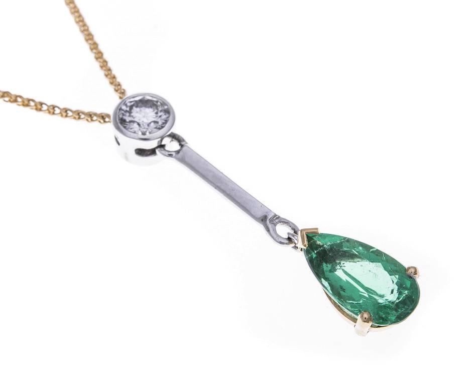 This sleek and elegant British made pendant is crafted from 18ct yellow and white gold and set with a gorgeous verdant green emerald and a sparkling accent diamond. A wonderful gift for and emerald wedding anniversary or a May birthday.