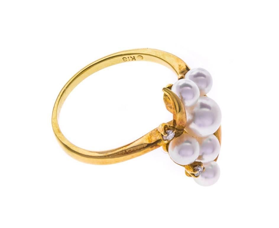 From the extraordinary designers at Mikimoto comes this fabulous dress ring. Six gleaming white pearls with lustrous pink overtones sit nestled between two scintillating diamonds on curling golden leaves. A certain celebration jewel that can be