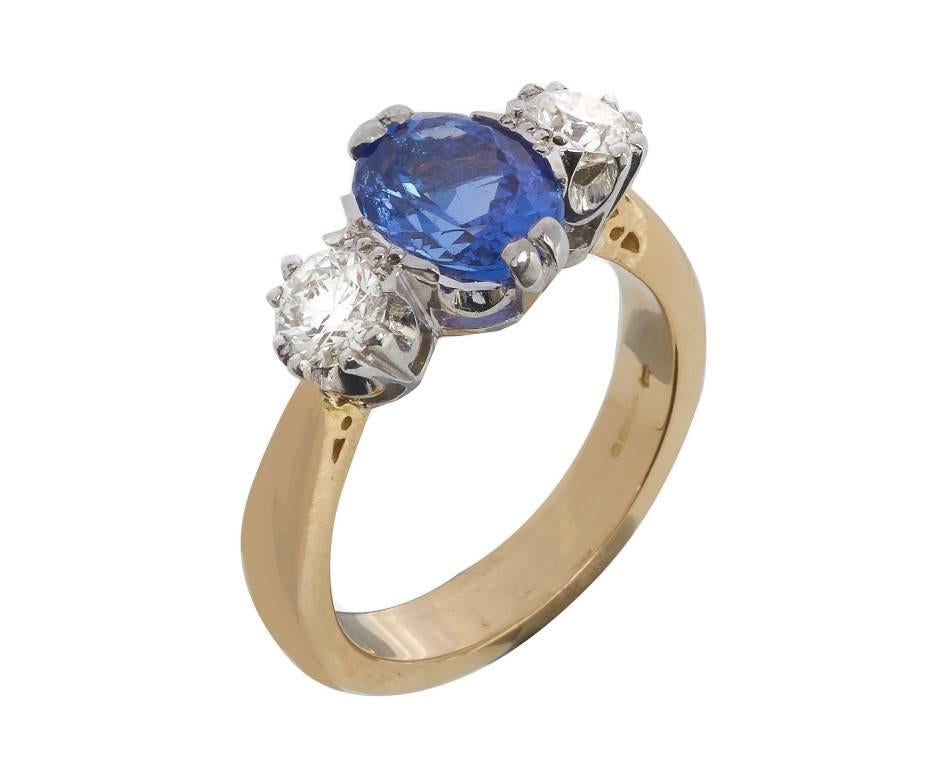 A classic trilogy ring design, centrally set with a 2.33ct tanzanite between two round brilliant cut diamonds totalling 0.86ct. The gems are set in traditionally styled white claws to yellow chenier shoulders and shank. A lovely idea for celebrating