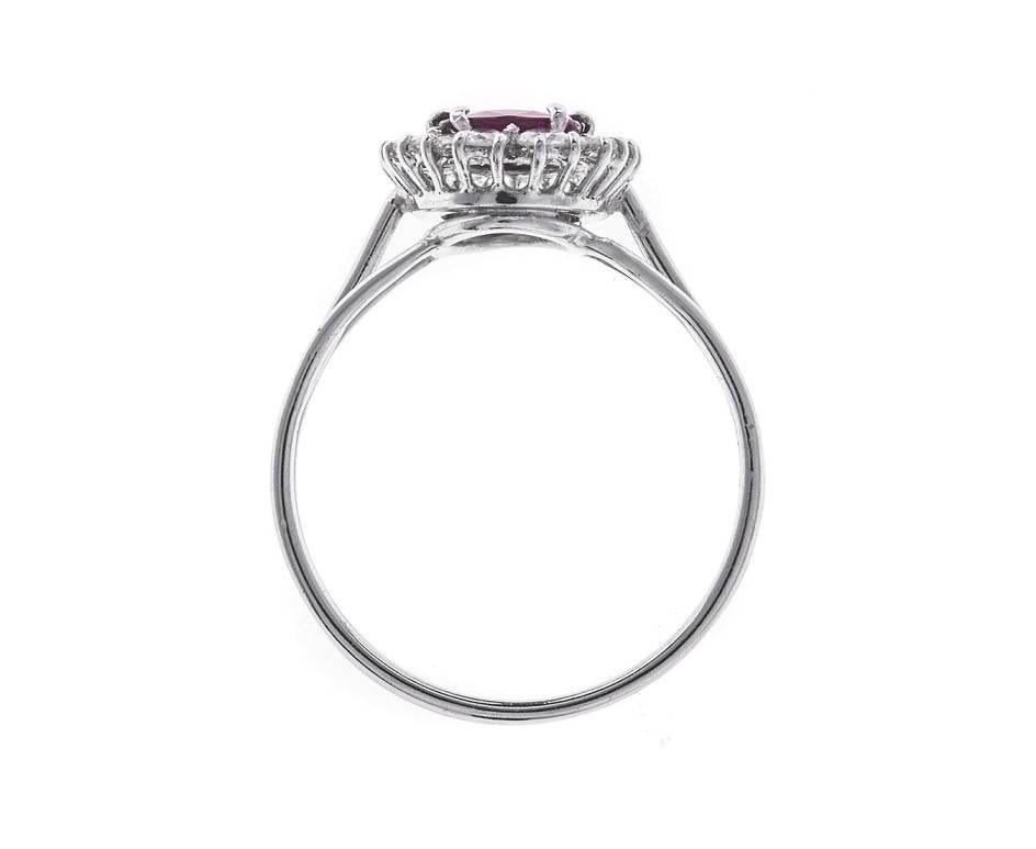 A hand-made and unique design taking traditional jewellery values and adding a modern twist. A blood red ruby (approx. 0.75ct) is set in the centre of diamond halo, totalling approx. 0.51ct. A hand-assembled white wire work band splits three ways to