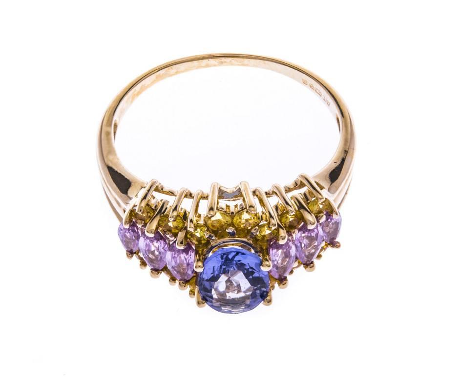 An opulent and colourful 9ct gold cluster ring set with an oval faceted tanzanite, marquise cut pink sapphires and round faceted yellow sapphires creating a kaleidoscope of sparkle and colour.

SPECIFICATION
Weight