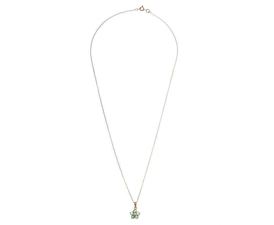 A delicious 18ct gold Pendant (as tested) set with vivid green emeralds in a floral arrangement surrounding a sparkling diamond and suspended from a sleek 18ct gold curb chain. A beautiful gift for a May birthday or an emerald
