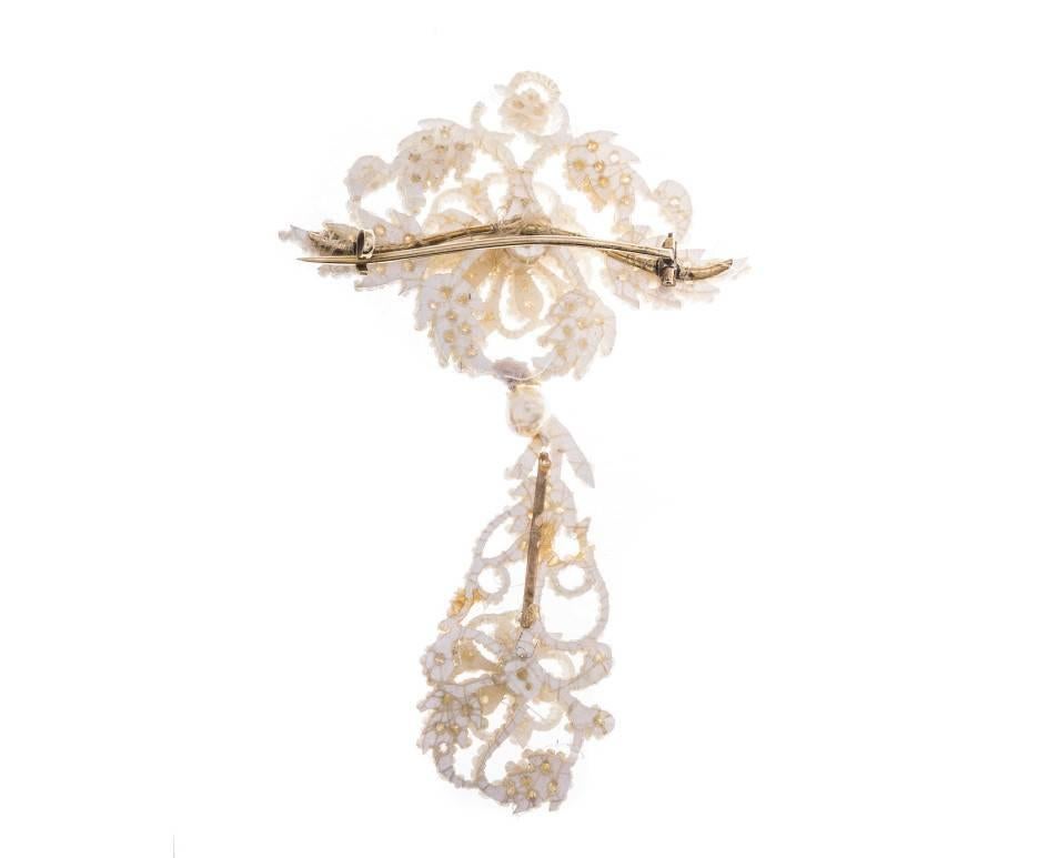 Crafted with such delicate intimacy, this superbly beautiful brooch is made from tiny seed and split pearls, hand threaded and attached to a mother of pearl backing. Appearing like flowers and feathers, this delightful - but delicate - accessory is