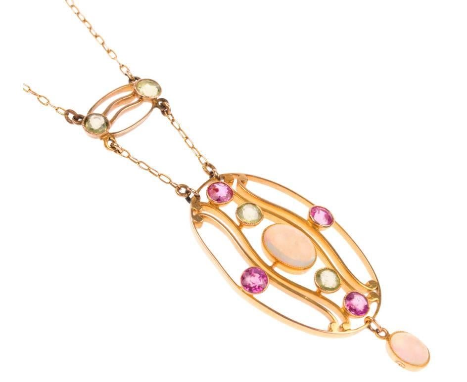 GEMMOLOGIST'S NOTES
This breathtaking early 20th century necklet was crafted during the Arts and Crafts era.

With a central opal with dazzling green, blue and red flashes of colour, enhanced by the vivid peridot and garnet