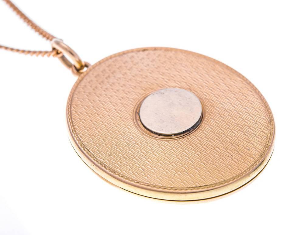 This sleek and stylish Art Deco locket is fashioned in gold and engraved with an intricate but simple repeating pattern on both sides. One side has a disc of gold perfect for initials. It has one gallery window for a cherished loved one, a wedding