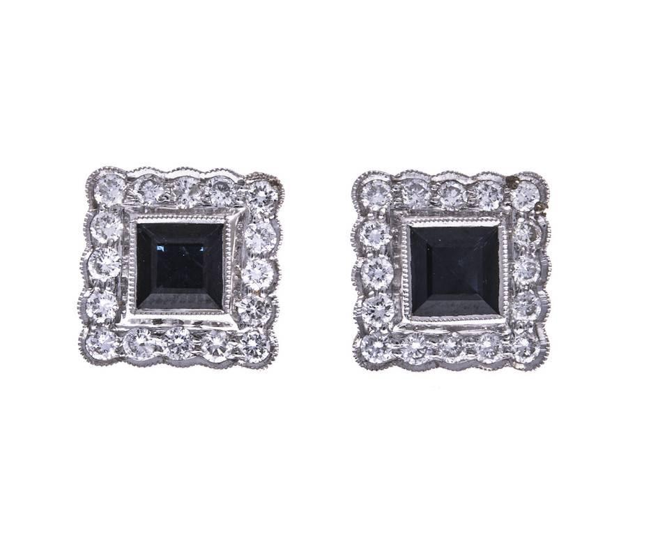 Rich blue square cut sapphires framed in 18ct  white gold and diamonds complete with yellow gold fittings. These sumptuous stud earrings are British made and would make an excellent gift for a sapphire occasion or a September birthday