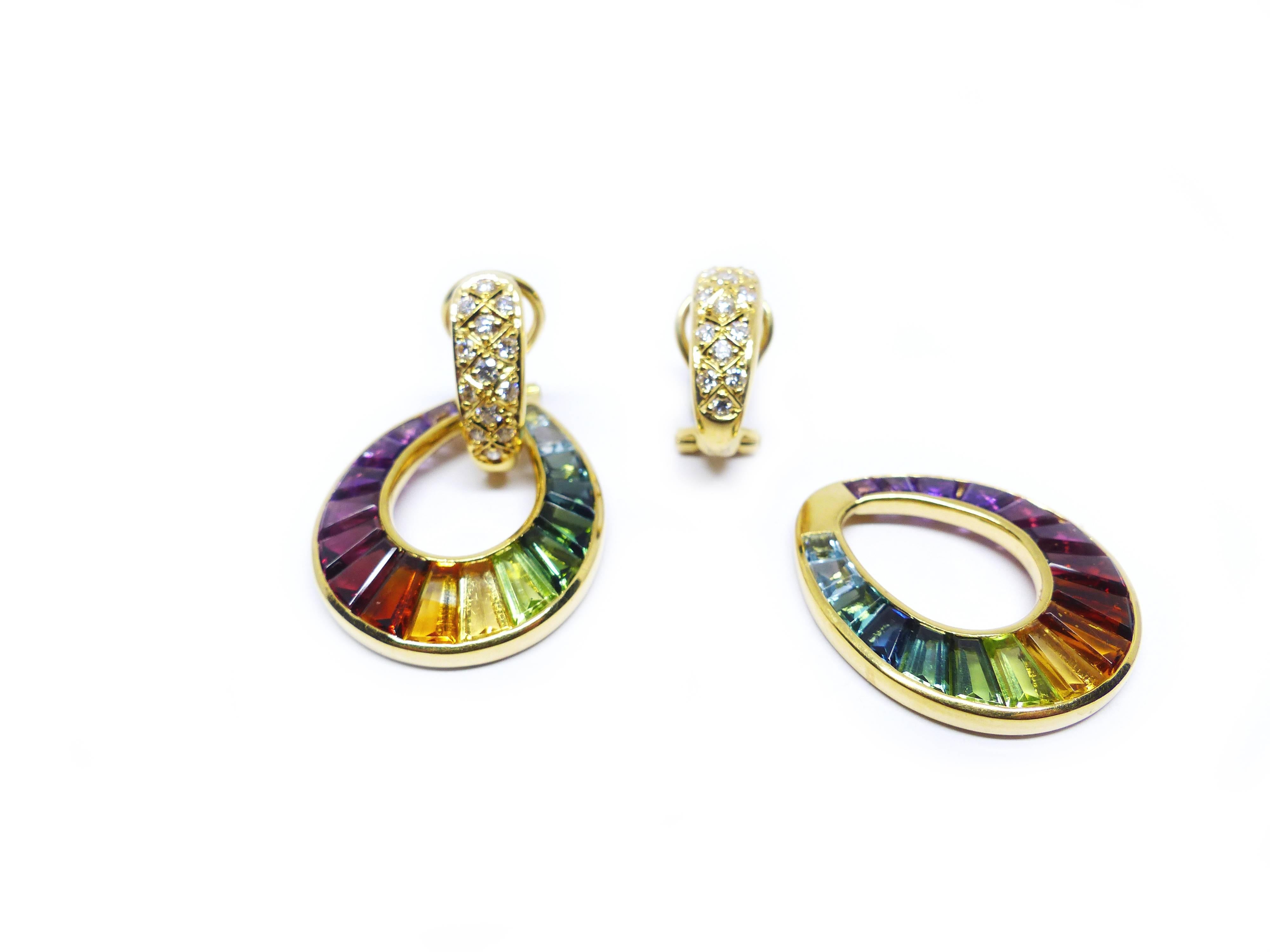 This 18k yellow gold pair of earrings with 34 different gemstones in top quality, tapez cut (8,59cts), set in the colours of a rainbow. Clips at the back.

18k Yellow Gold (14.77g)
Rainbow Multi-Colour Gemstones (34x tapez cut - 8.59ct)
Diamonds