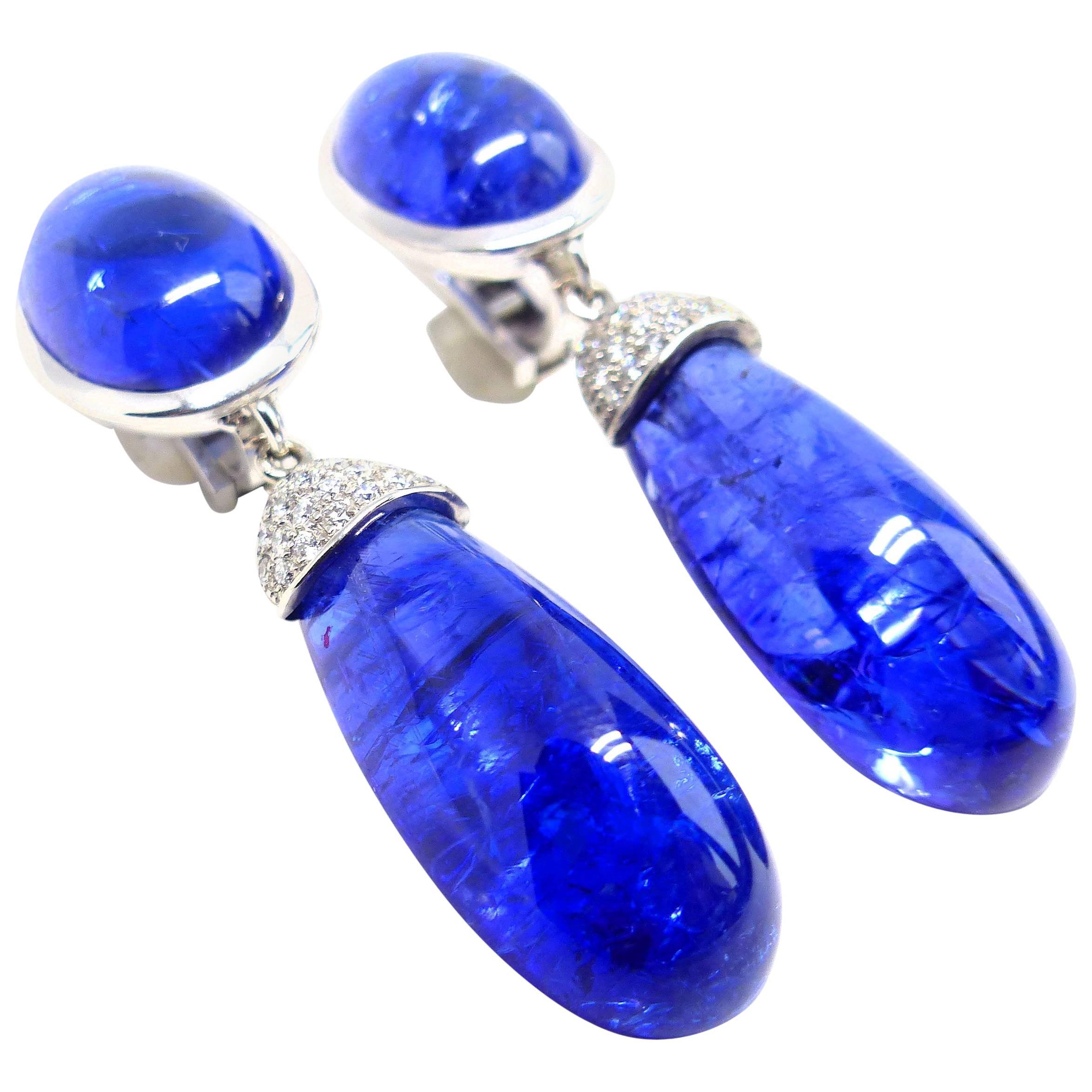 Thomas Leyser is renowned for his contemporary jewellery designs utilizing fine coloured gemstones and diamonds. 

These pair of earrings in 18K white gold (13.38g) are set with 2x fine Tanzanite Cabouchons (oval, 16x12mm, 21.76ct). + 2x Tanzanite