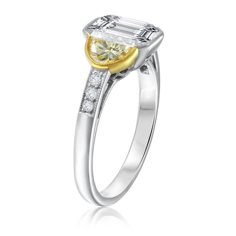 Gorgeous Platinum Engagement Ring set with a 2.00 Carat Emerald Cut Diamond. G in color and VS2 in clarity.  This rings beautiful center stone is flanked by two half moon shaped cut yellow diamonds equaling 0.35 cttw. and 6 brilliant round cut