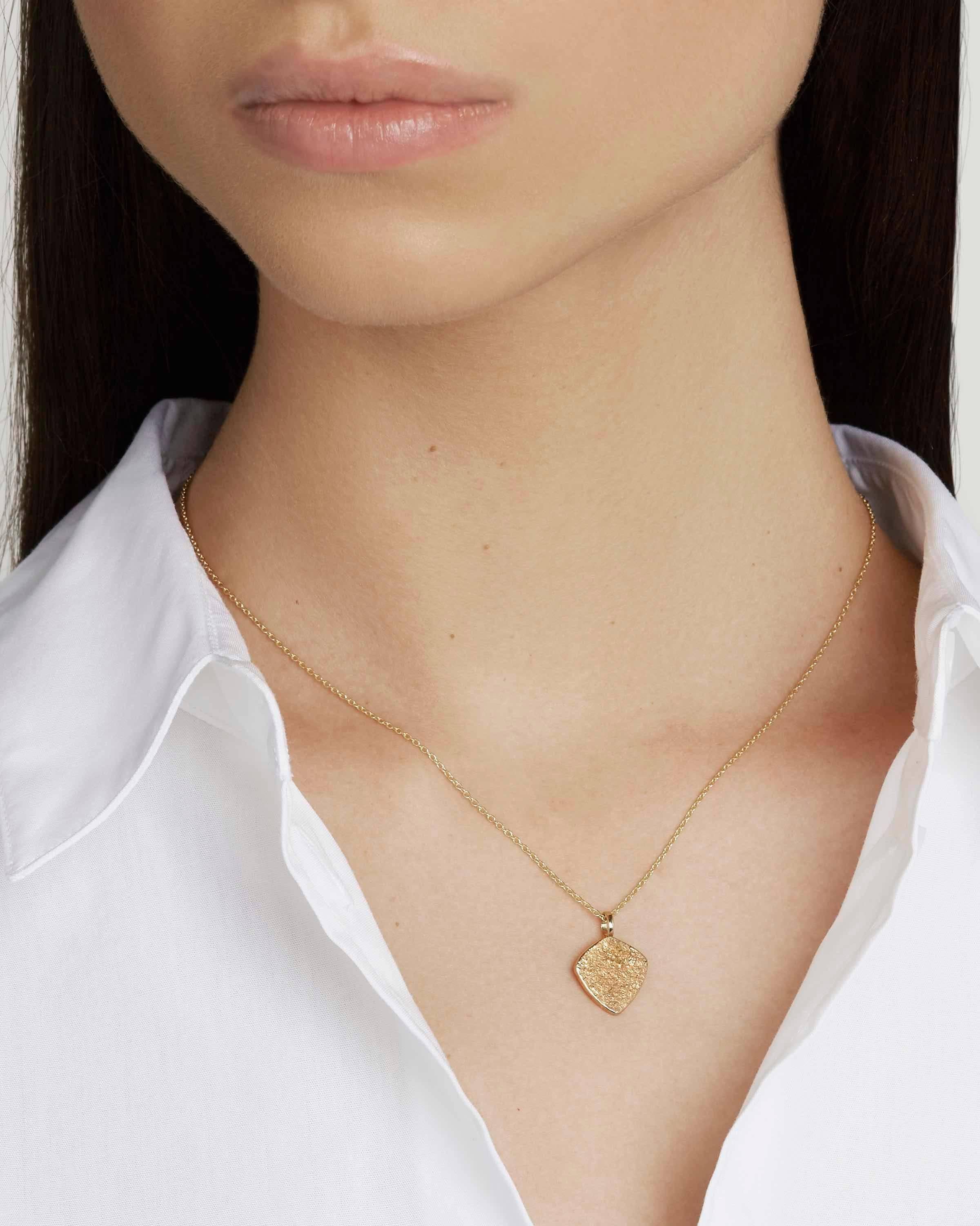 This versatile, classic pendant necklace is crafted in solid 18-carat yellow gold and features our signature Paper texture.  Perfect for layering, the pendant comes on a 18-inch chain in solid 18-carat gold.  Pendant is 1.8 mm long by 1.3 mm wide.