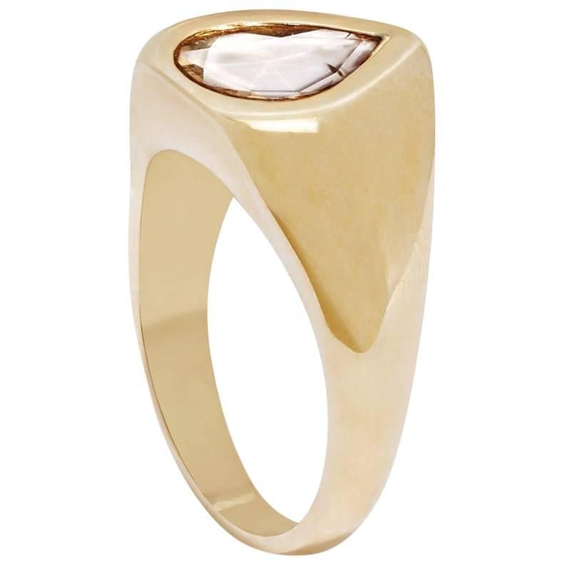 This ring offers a bold update on the traditional engagement ring with a curvaceous signet-inspired shield shape and a light brown pear-shaped rosecut diamond.  The ring is handcrafted in solid 18-carat yellow gold and features an approximately 0.8