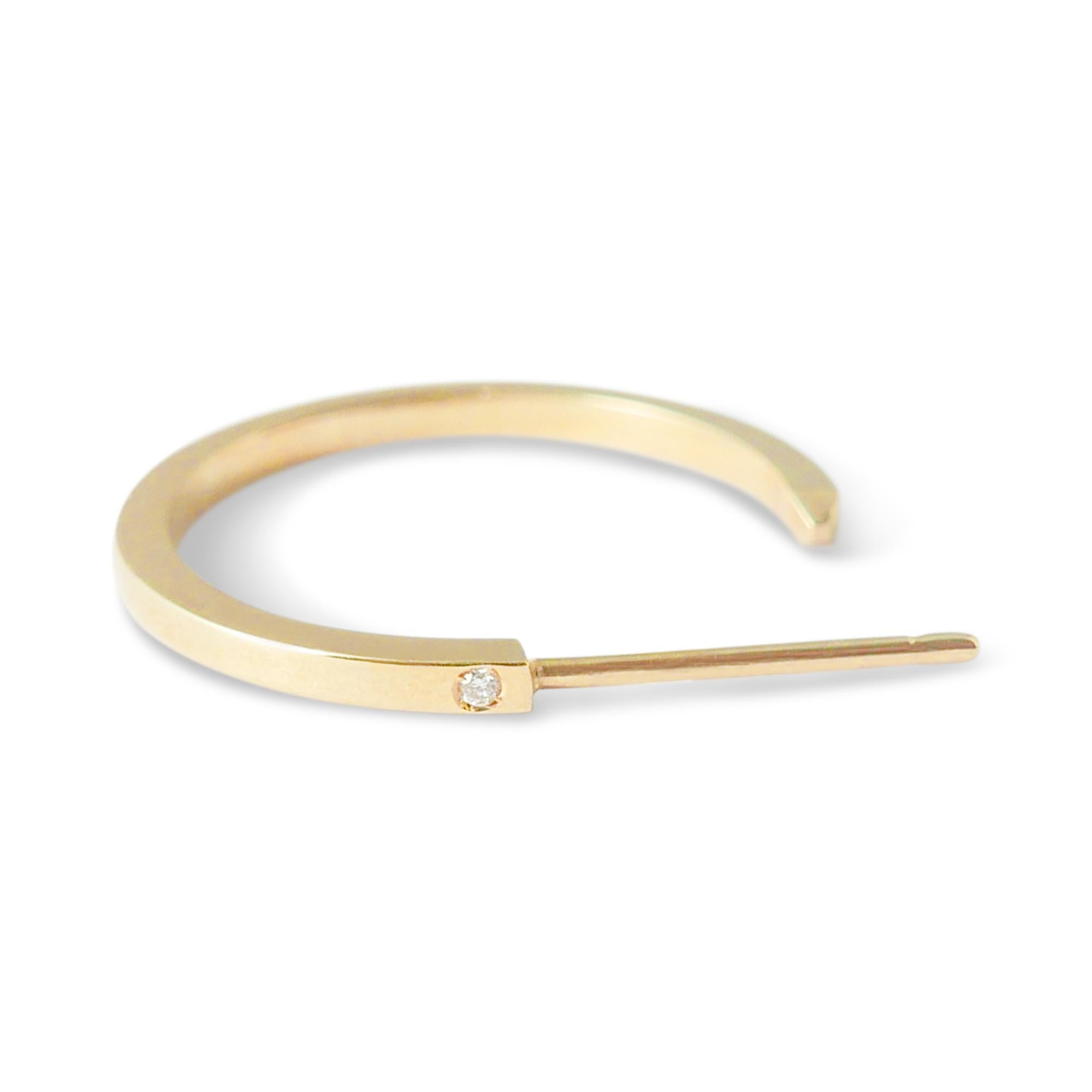 Clean-lined and minimalist, these solid 18-karat gold hoop earrings feature two tiny H-VS1 diamond accents on each hoop.  Measuring 1.9 cm in diameter, the hoops feature a classic post and butterfly fastening. 

Handmade in London.  Hallmarked 750