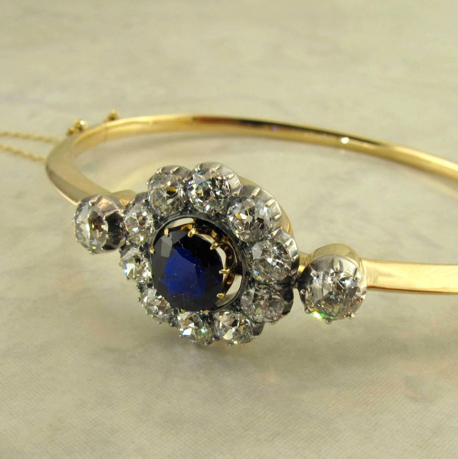 14k yellow gold and silver antique Victorian sapphire and diamond bangle bracelet.
The knife edge bangle fitted with a one piece removable top featuring a center round AGL certified natural untreated sapphire measuring 7.29 x 6.40 x 3.86 mm,
with an