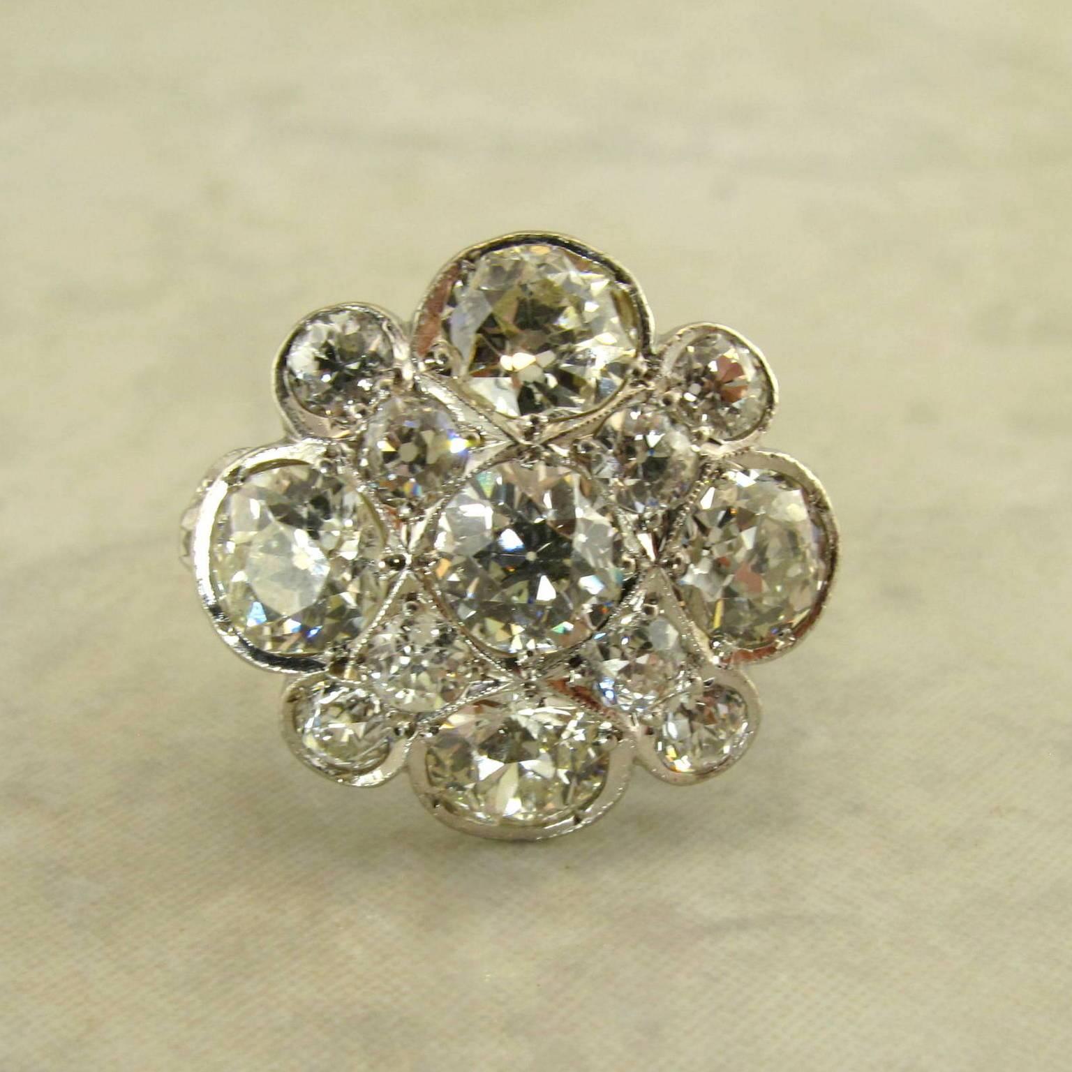Platinum Old Mine Cut Diamond Cocktail Ring.
The cluster style ring top set with thirteen old mine cut diamonds and two on the shank, weighing approximately 3.0 carats total, with open work under gallery.
Size 6, including balls, easily sized.
Circa