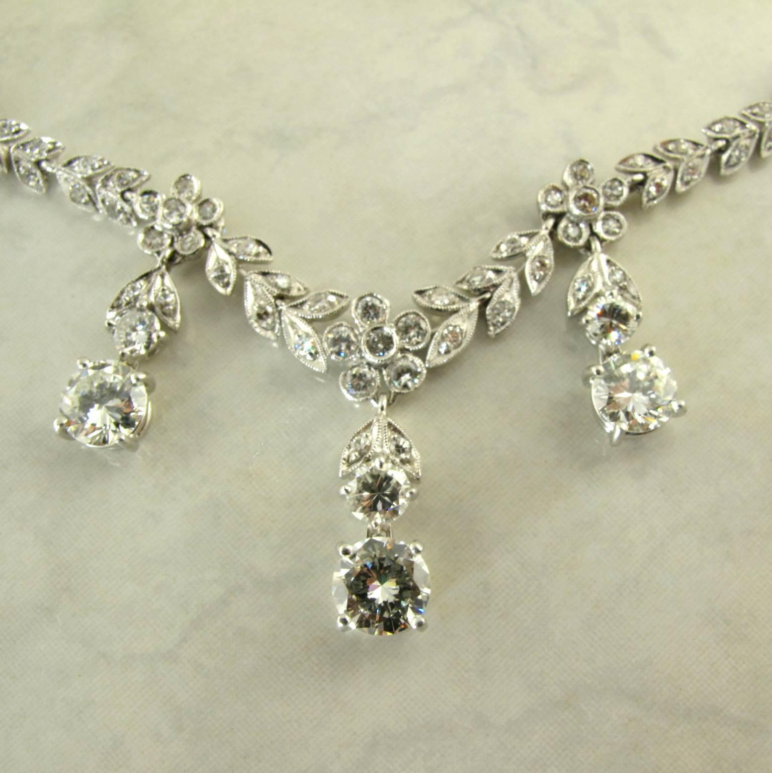 18K White Gold Diamond Necklace. 
The mid century necklace with flower and leaf design with seven drops, set with seven large brilliant diamonds weighing approximately 4.75 carats, embellished by two hundred small diamonds weighing approximately