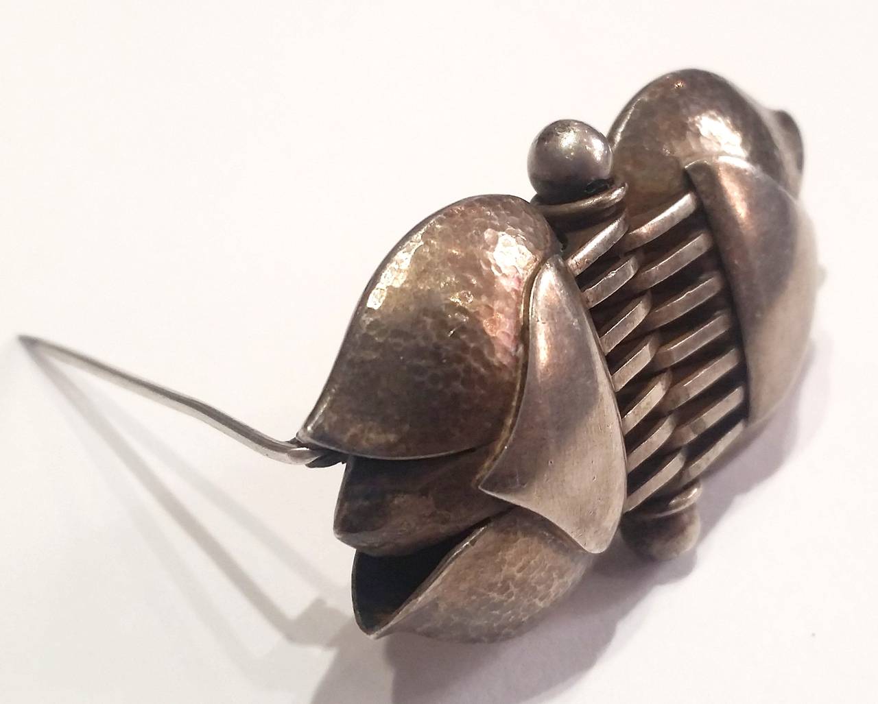 Art Decó silver brooch by very important Spanish painter and goldsmith Jaume Mercade. Tulip shape with central joint representing a hinge.

Martelé and polished silver handwork
Signed