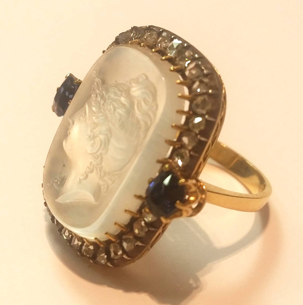 19th Century carved moonstone ring depicting a fine lady. 
Made of yellow gold, silver, diamond and sapphires.

Size:  14 Europe. 
           6 3/4 USA