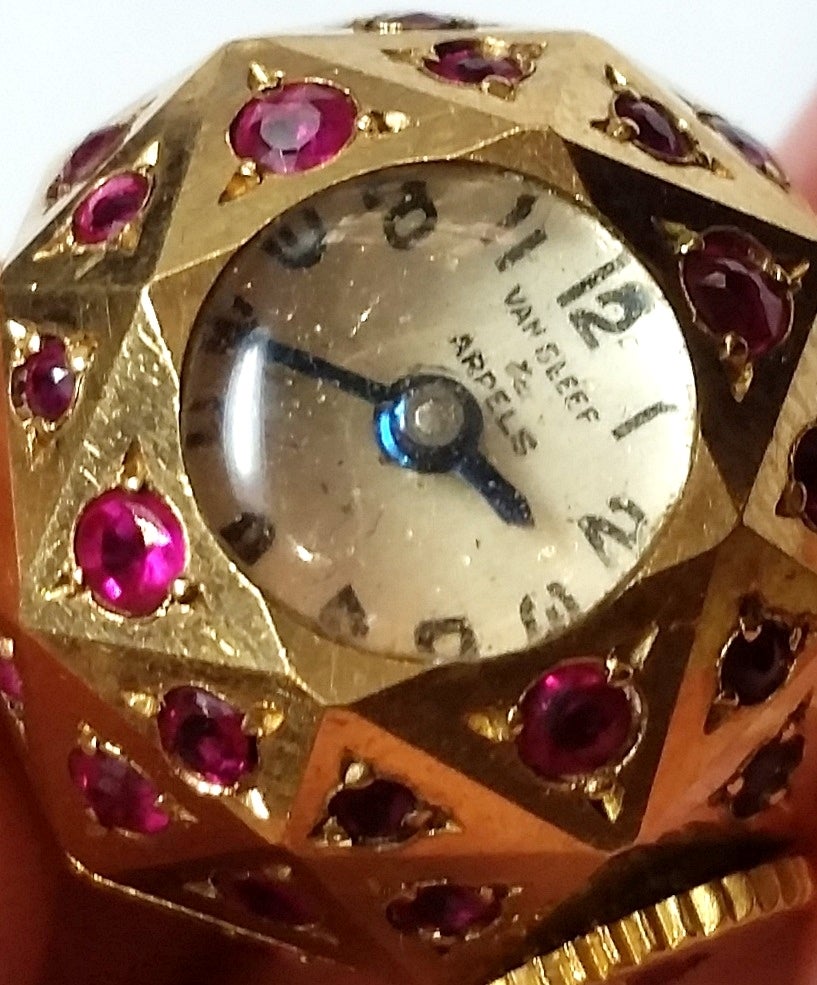 Van Cleef & Arpels lady's lapel watch in yellow gold with circular-cut rubies.
Signed on the dial and numbered on the back.