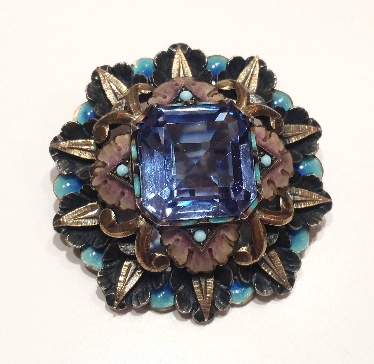 Catalan Art Deco brooch made of silver, silver gilt, enamel and a square cut blue spinel.