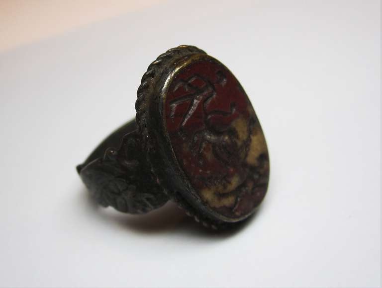 Greco-Phoenician bronze hoop ring with oval shaped red jasper. Intaglio depicting two human figures armed with clubs and attacking a lion. On the back there are three lines of an inscription in Greek.

Archelogical Piece
20mm Diameter - Ring Size