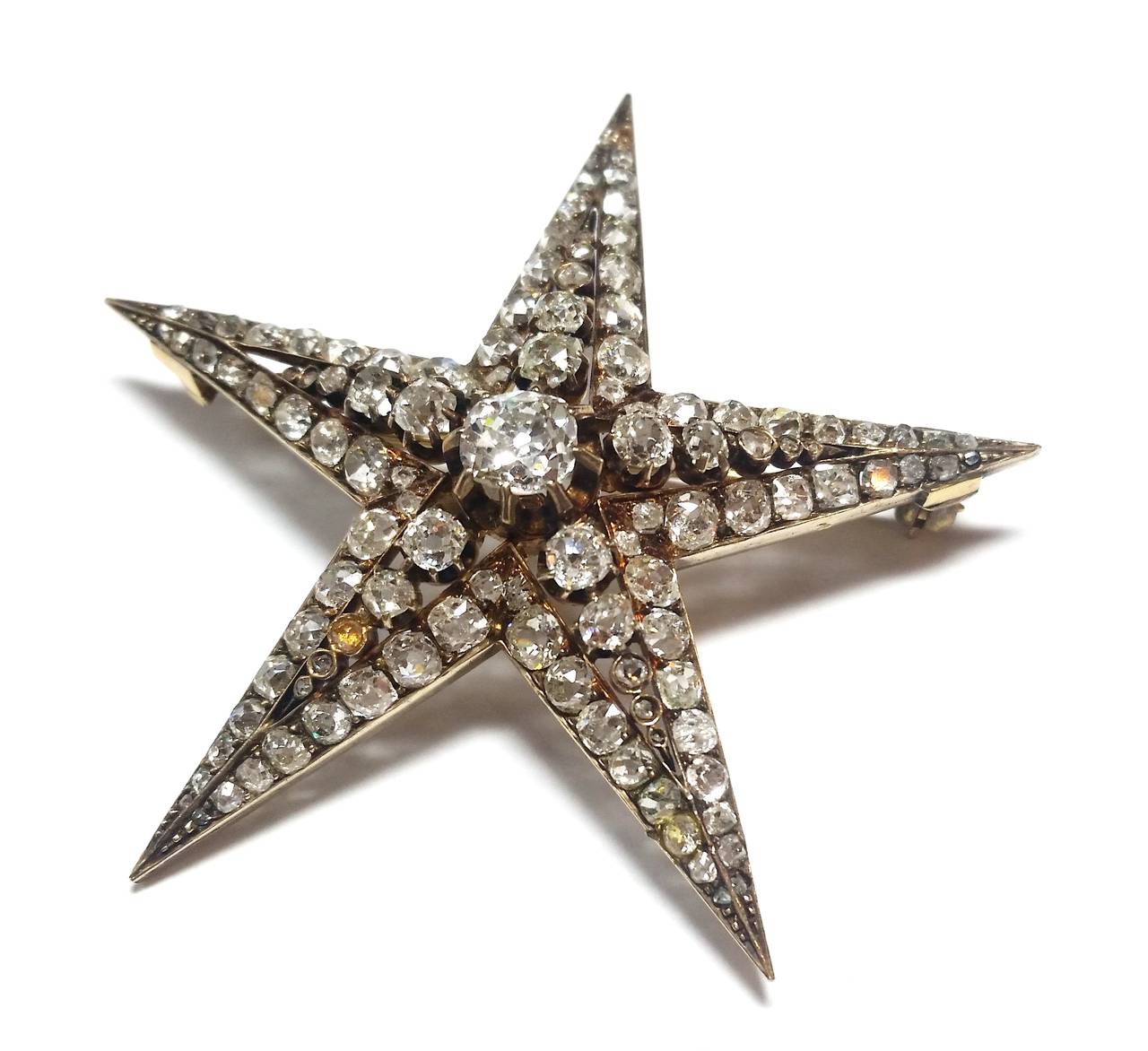 Yellow gold and diamond star brooch. 
French gold marks
Central diamond is an antique cushion cut 0.75ct approx.
The rest of them are cushion and old european cuts weighting in total 5ct approx.