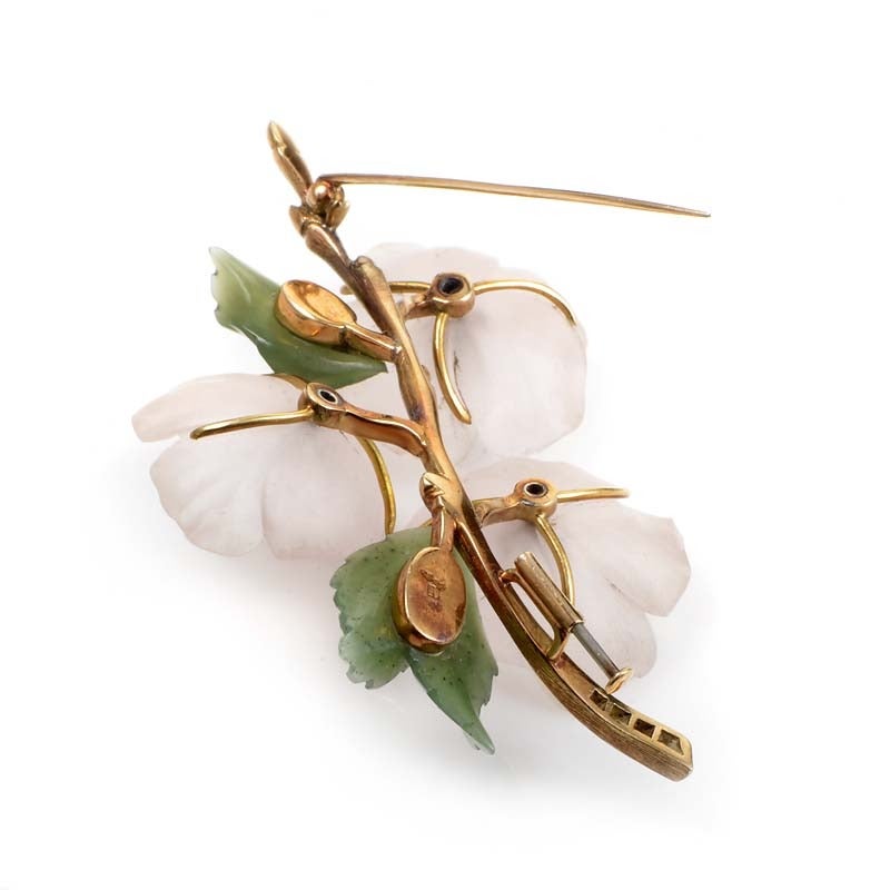 A gorgeous representation of the beauty of the natural world, this brooch is an instant classic. The brooch looks like a flowering branch made of 14K yellow gold accented with green jade leaves and pink quartz flowers. Lastly, ~.75cttw of diamonds