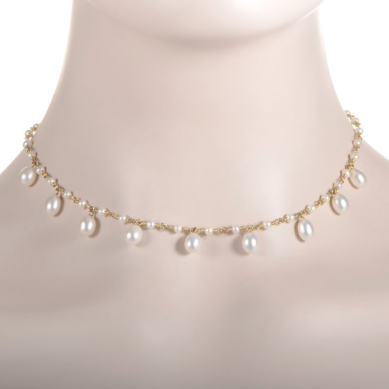 Petite pearls bring the design of this choker necklace from Tiffany & Co. to life! The necklace is made of 18K yellow gold and features pearls in the design as well as dangling from the necklace itself.