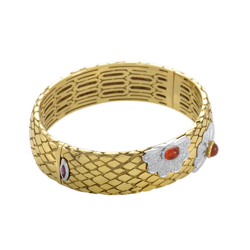 Let the energies of good fortune and good luck from the joyful orange citrine gemstone of this floral bangle light up your life. Featuring a solid, immaculate design of 18K yellow and white gold set with diamonds, this bangle will add a fantastic