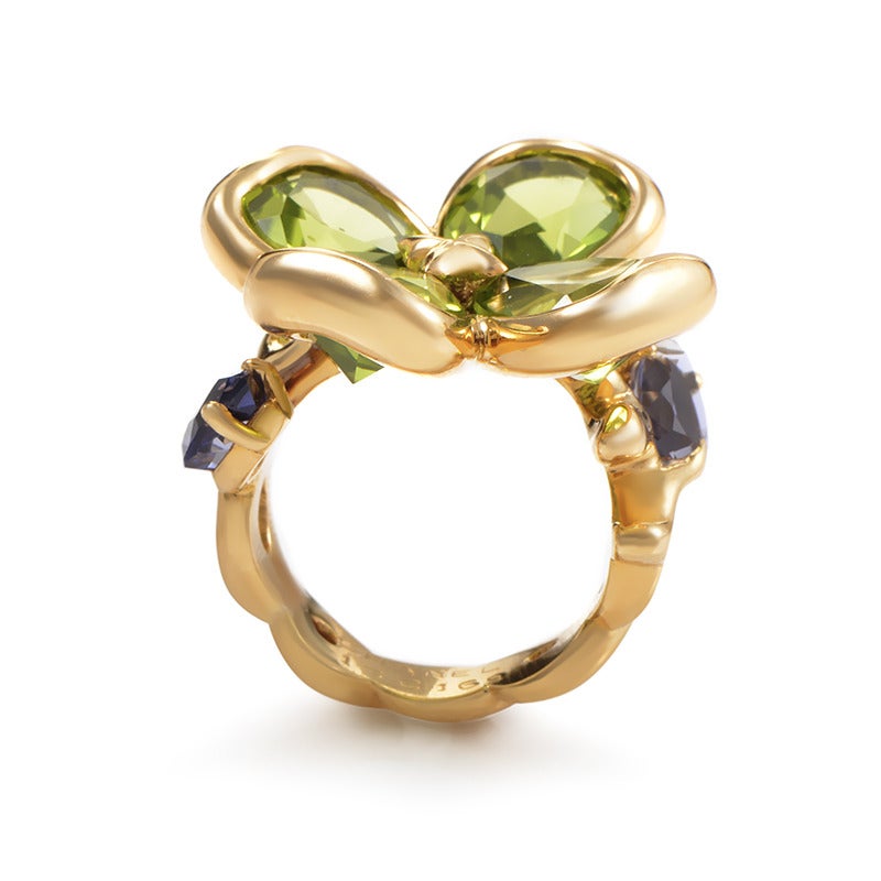 This gorgeous ring stays faithful to Chanel’s tradition of feminine creations with its majestically designed body vivaciously accented with attractive green peridot and purple iolite stones. The ring is made of 18K yellow gold and weighs 15