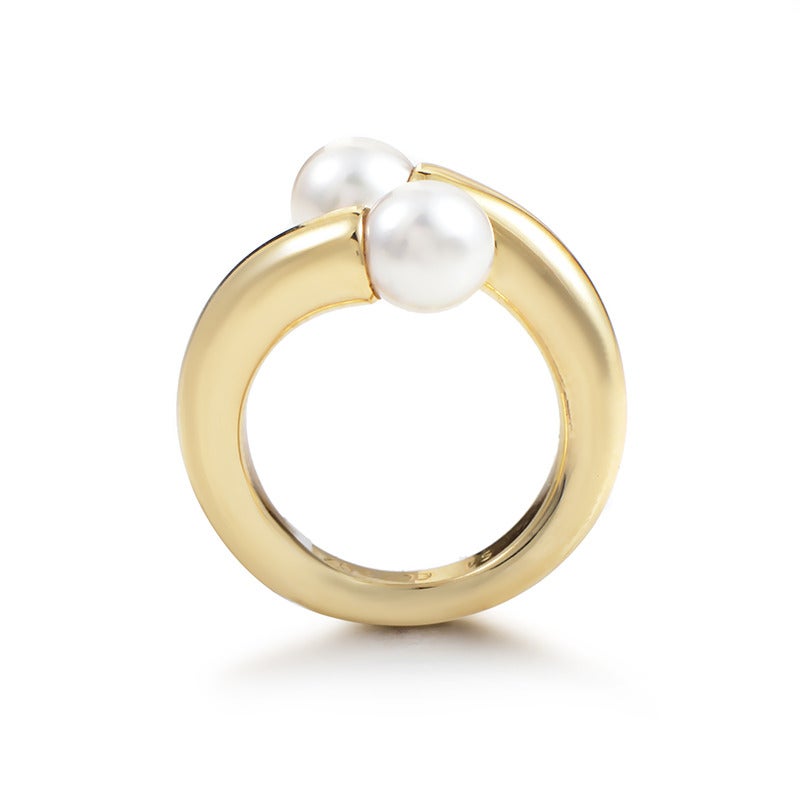 Elegant, tasteful ring by the esteemed Cartier, made of stylish 18K yellow gold and accented with two gorgeous pearls.

Ring Size: 6.5 (52 3/4)