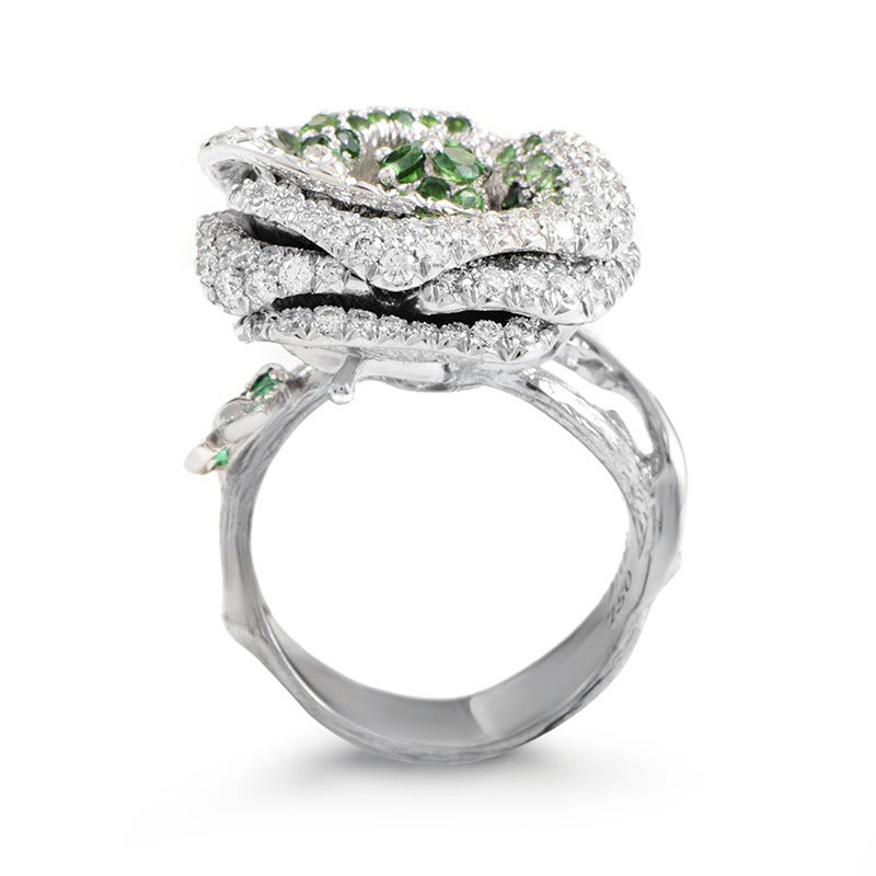 We are rarely presented with a jewelry piece this astonishing and extravagant; made of prestigious 18K white gold, this Dior ring depicts a graceful blossomed rose, lavishly decorated with sparkly diamonds and attractive green tsavorite
