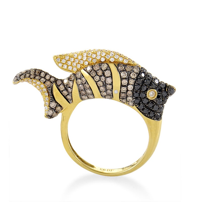 The slicing arc of a shimmering dorsal fin is the tip of this graceful spectacle. 18K yellow gold shapes the trajectory of a resplendent fish design, cutting stripes through a contrasting sea of 1.93ct diamonds.

Ring Size: 7.25 (54 5/8)