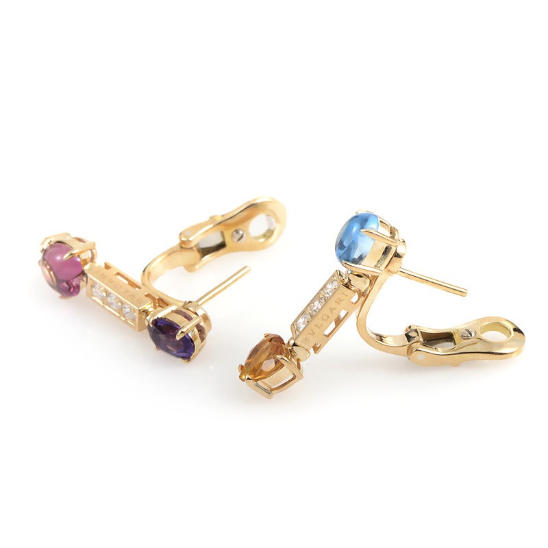 This pair of Bulgari earrings have a whimsical and ethereal glow. They are made of 18K yellow gold and are accented with three diamonds each as well as a gemstone cabochon.