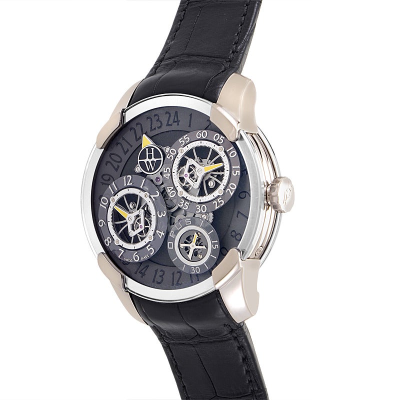 Harry Winston gents' 18K white gold manually wound wristwatch with matching bezel on a black alligator leather strap. Watch displays indication of time by modules for hours, minutes, and seconds mounted on a platform that continuously rotates every