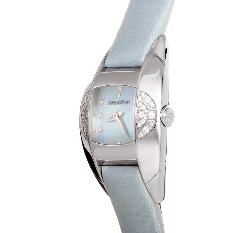 Audemars Piguet lady's 18K white gold automatic wristwatch with diamond-set bezel on a blue satin strap. Watch displays indication of hours and minutes on a blue mother-of-pearl dial. Watch resists water to ~20 meters/65 feet.