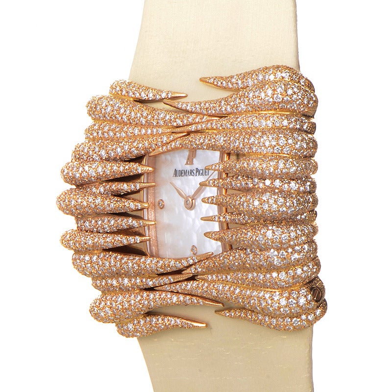 Audemars Piguet lady's 18K rose gold diamond-set wristwatch on a tan satin strap. Watch displays indication of hours and minutes on a mother of pearl dial. This piece is not suitable for any aquatic use.